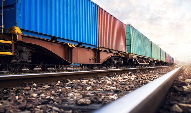 Train wagons carrying cargo containers for shipping companies.